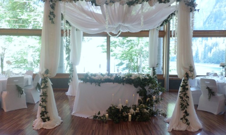 Espace mariés avec cascades de verdure fleurit et bougeoirs élégants. 